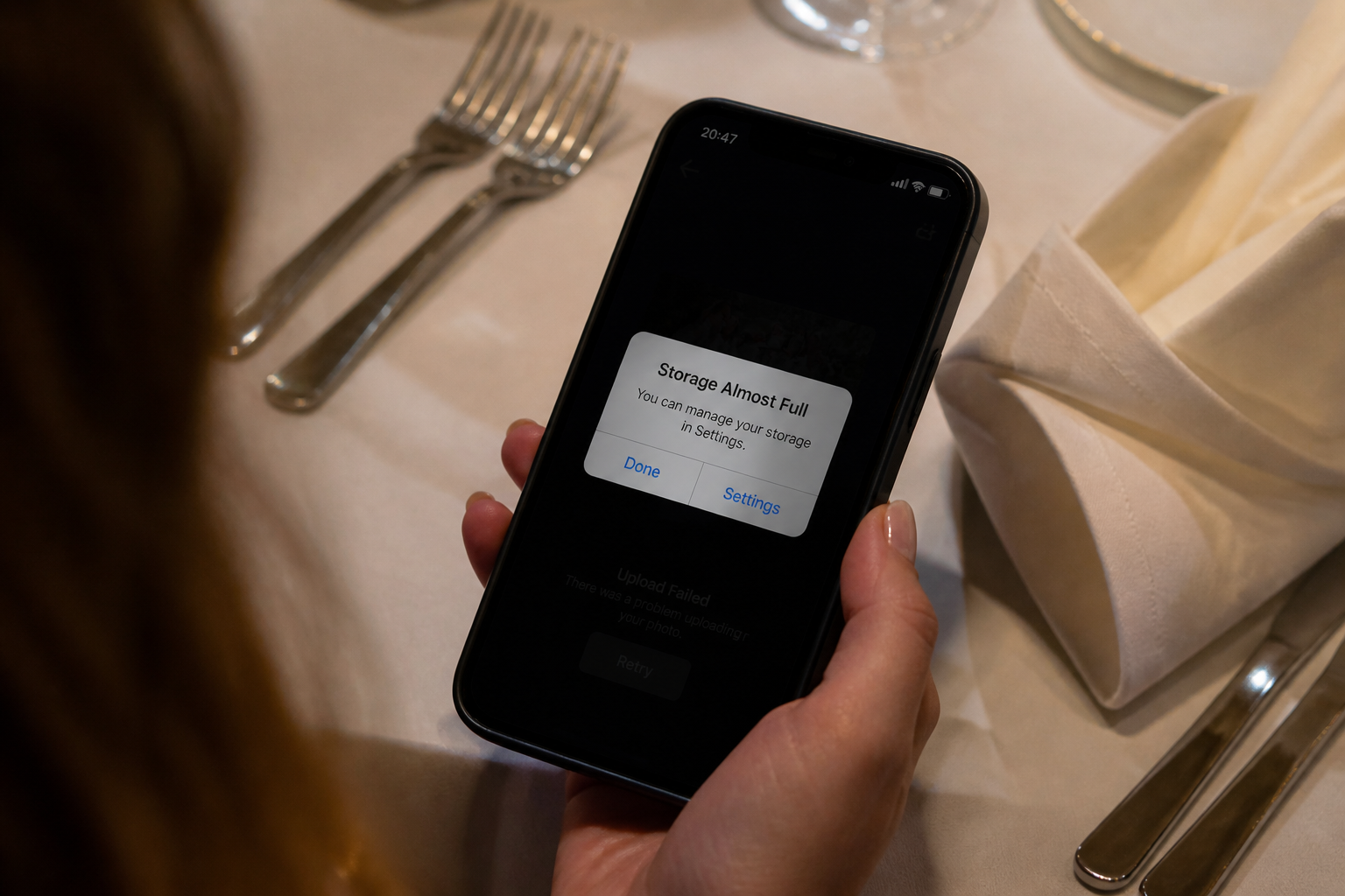 A phone held over a wedding table showing a storage-almost-full warning