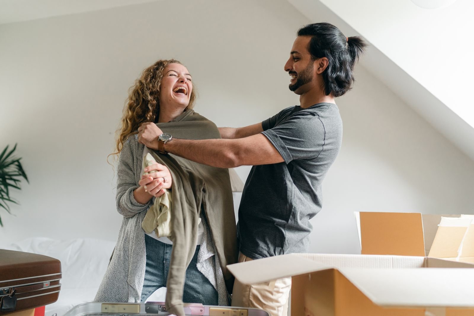 Smiling couple unpacking moving boxes in their new home