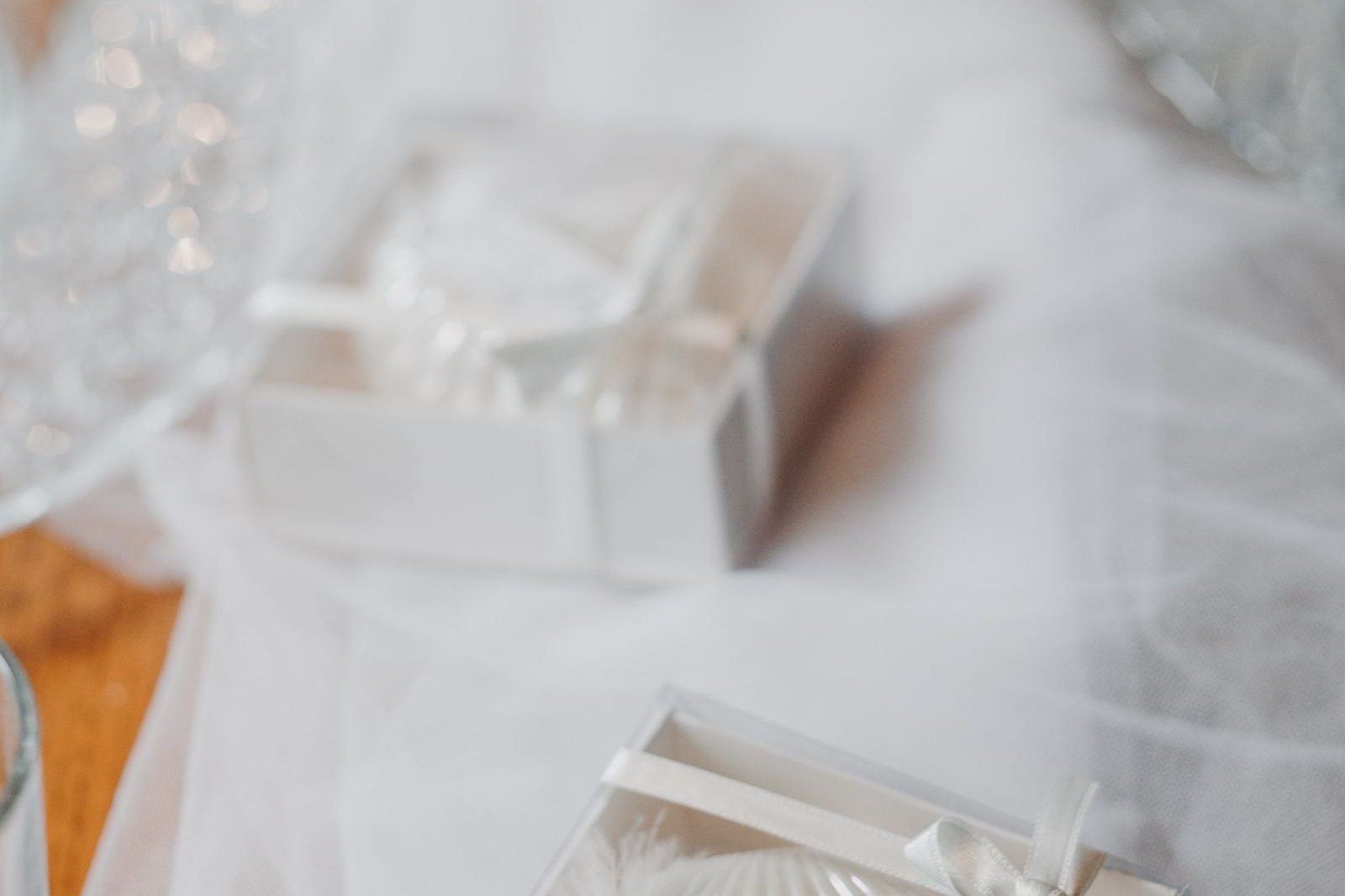 White gift boxes with wedding name tags on soft tulle