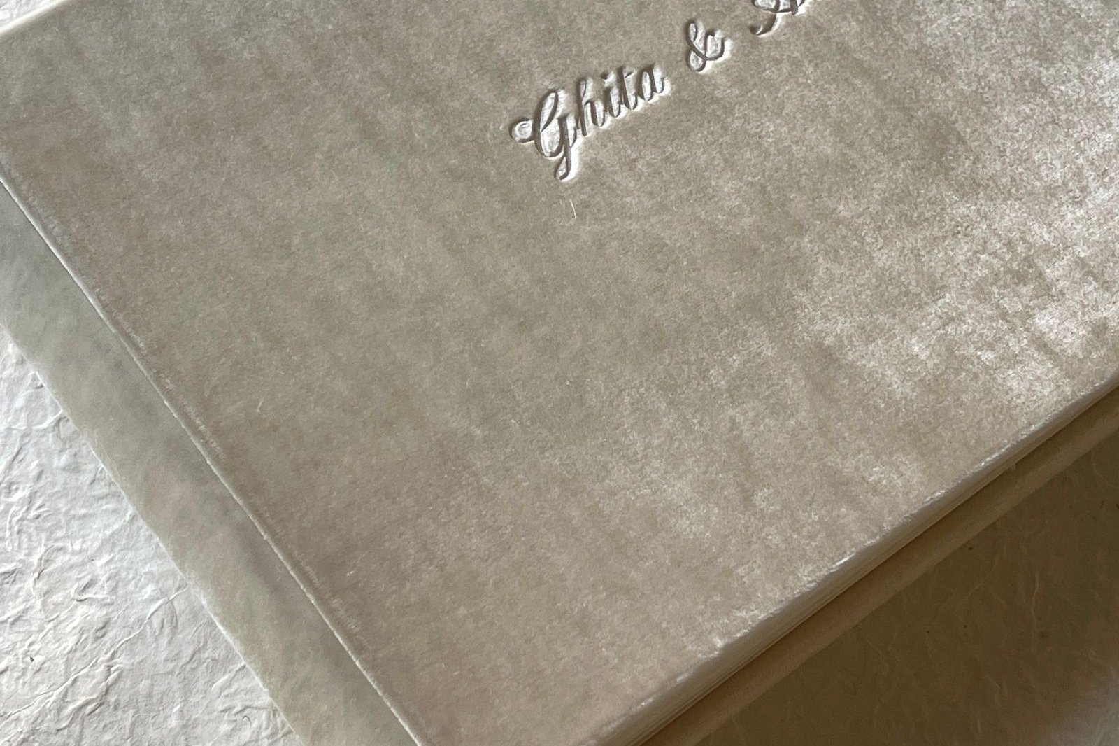 Velvet-covered wedding photo album with embossed names