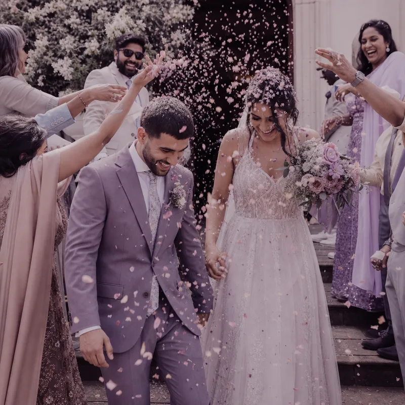 Guests throwing confetti over the newlyweds