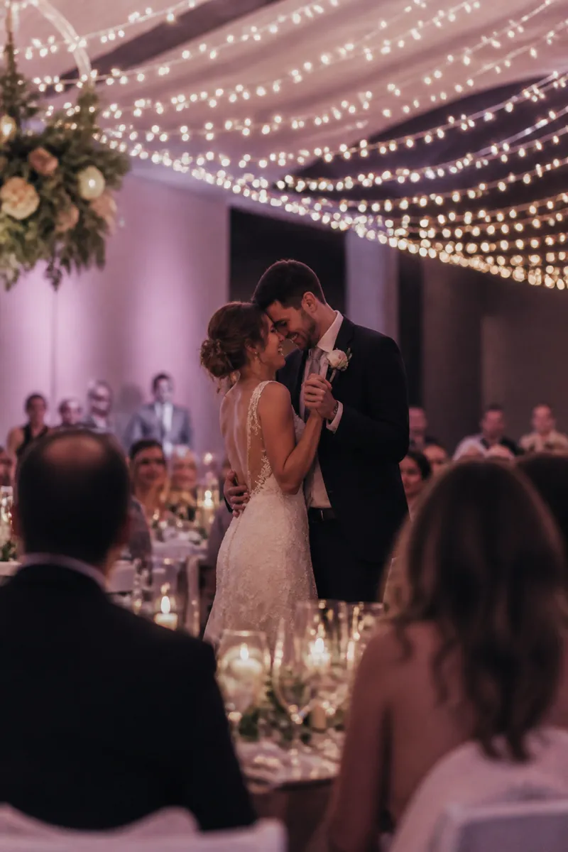 Guest photo of the couple's first dance under string lights